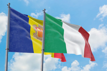 Italy and Andorra flags waving in the wind against white cloudy blue sky together. Diplomacy concept, international relations.