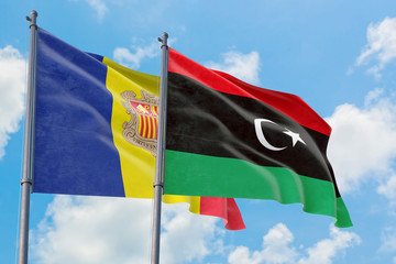 Libya and Andorra flags waving in the wind against white cloudy blue sky together. Diplomacy concept, international relations.