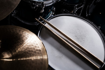Closeup of drumsticks lying on the drum set