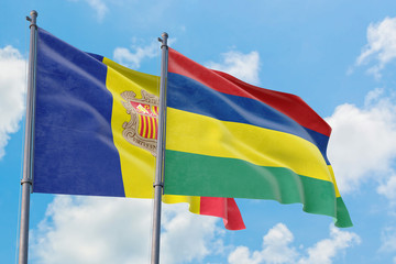 Mauritius and Andorra flags waving in the wind against white cloudy blue sky together. Diplomacy concept, international relations.
