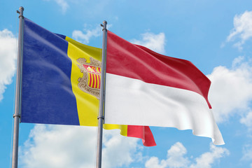 Monaco and Andorra flags waving in the wind against white cloudy blue sky together. Diplomacy concept, international relations.
