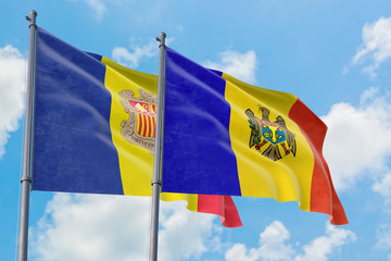 Moldova and Andorra flags waving in the wind against white cloudy blue sky together. Diplomacy concept, international relations.