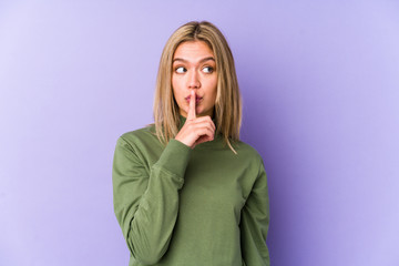 Young blonde caucasian woman isolated keeping a secret or asking for silence.