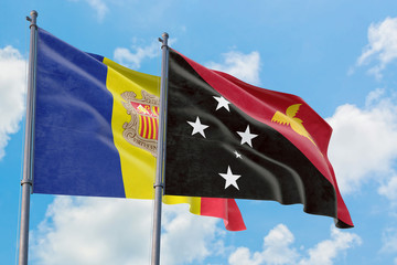Papua New Guinea and Andorra flags waving in the wind against white cloudy blue sky together. Diplomacy concept, international relations.