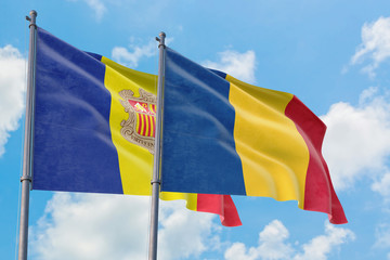 Romania and Andorra flags waving in the wind against white cloudy blue sky together. Diplomacy concept, international relations.