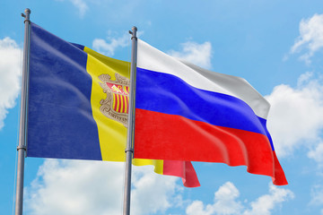 Russia and Andorra flags waving in the wind against white cloudy blue sky together. Diplomacy concept, international relations.