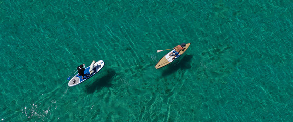 Aerial drone ultra wide photo of friends practising in SUP or Stand Up Paddle in tropical exotic...