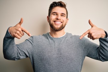 Young handsome blond man with beard and blue eyes wearing casual sweater looking confident with...