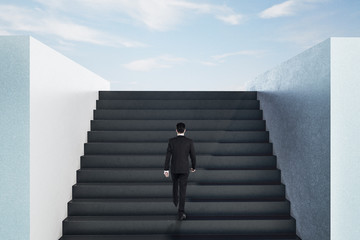 Businessman walking on top ladder