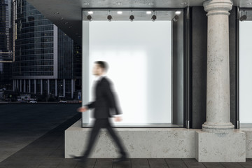 Businessman walking  near shop window