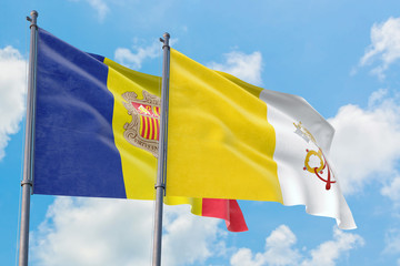 Vatican City and Andorra flags waving in the wind against white cloudy blue sky together. Diplomacy concept, international relations.