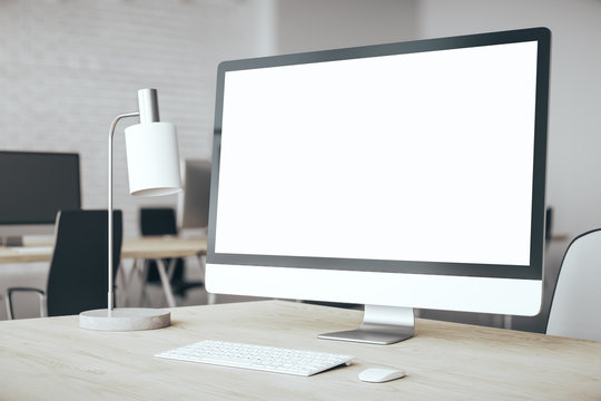 Designer desktop with empty white computer screen