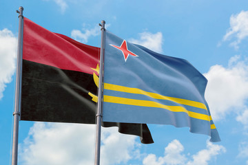 Aruba and Angola flags waving in the wind against white cloudy blue sky together. Diplomacy concept, international relations.