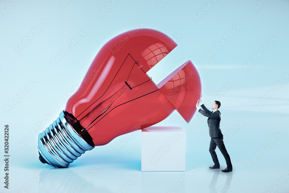 Canvas Prints businessman pushes a big red light bulb.