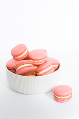 Pink macaron in a white plate on a white isolated background
