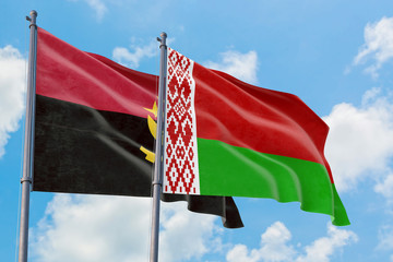 Belarus and Angola flags waving in the wind against white cloudy blue sky together. Diplomacy concept, international relations.