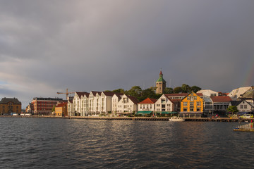 Stavanger, Norway - July 2019: The harbour in Stavanger city. This area is called Vagen. Evening with the rainbow