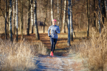 Young woman running training in autumn park