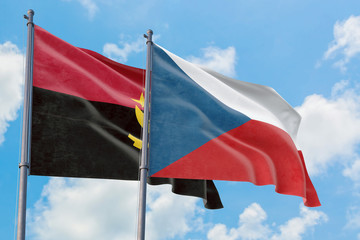 Czech Republic and Angola flags waving in the wind against white cloudy blue sky together. Diplomacy concept, international relations.