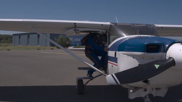 skydiver entering a small plane at small airport