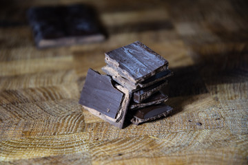 Dark chocolate with filling on a wooden table.