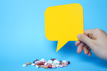 Pills and copy space with yellow speech bubbles on blue background.