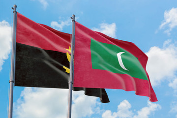 Maldives and Angola flags waving in the wind against white cloudy blue sky together. Diplomacy concept, international relations.
