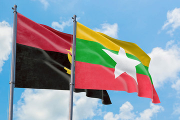 Myanmar and Angola flags waving in the wind against white cloudy blue sky together. Diplomacy concept, international relations.