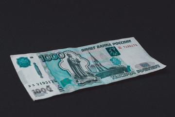 Russian banknote of 1,000 rubles is on a black background.