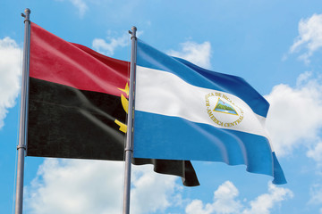 Nicaragua and Angola flags waving in the wind against white cloudy blue sky together. Diplomacy concept, international relations.