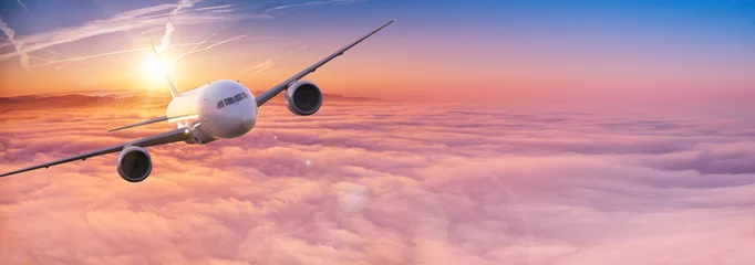 Fototapeten Kommerzieller Flugzeugjet, der bei schönem Sonnenuntergang über dramatischen Wolken fliegt. Reisekonzept. © Lukas Gojda