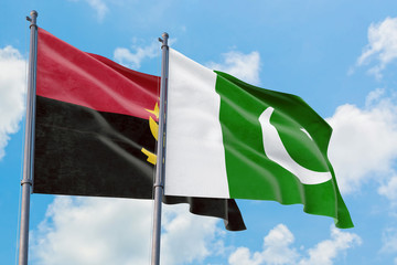 Pakistan and Angola flags waving in the wind against white cloudy blue sky together. Diplomacy concept, international relations.