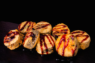 Traditional fresh japanese sushi rolls on a black background. Deep Fried Sushi.