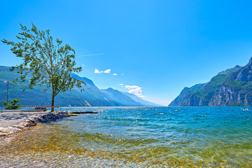Coast of the gorgeous Lake Garda surrounded by mountains in Riva del Garda, Italy.