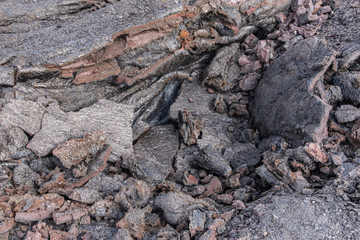 Leilani Estate, Hawaii, USA. - January 14, 2020: 2018 Kilauea volcano eruption hardened black lava field. Closeup of cracked layers of crust exposing red stones.