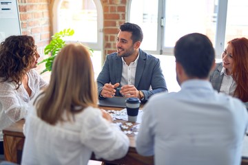 Group of business workers working together. Sitting on desk speaking at the office