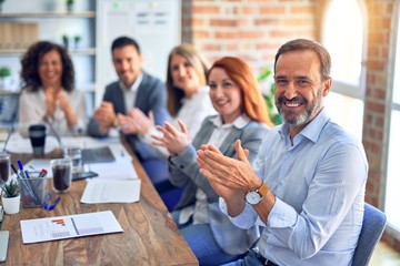 Group of business workers smiling happy and confident. Working together with smile on face looking at the camera applauding at the office