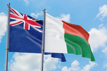 Madagascar and Anguilla flags waving in the wind against white cloudy blue sky together. Diplomacy concept, international relations.