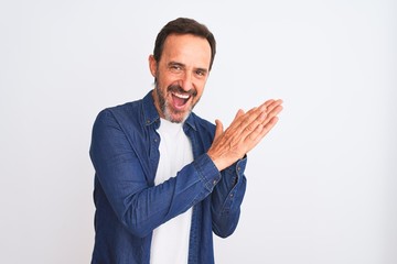Middle age handsome man wearing blue denim shirt standing over isolated white background clapping and applauding happy and joyful, smiling proud hands together