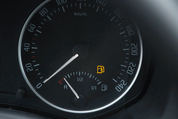 Empty fuel gauge warning light in car dashboard