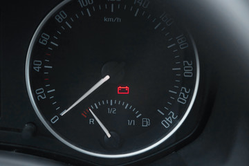 .Close up shot of a car dashboard with the battery icon lit.