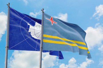 Aruba and Antarctica flags waving in the wind against white cloudy blue sky together. Diplomacy concept, international relations.