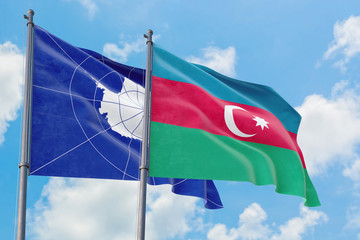 Azerbaijan and Antarctica flags waving in the wind against white cloudy blue sky together. Diplomacy concept, international relations.