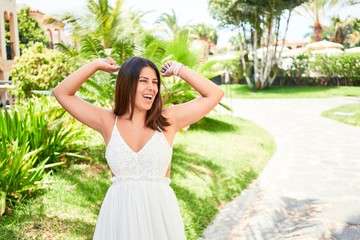 Naklejka premium Young beautiful woman celebrating and smiling happy enjoying sunny day of summer at hotel resort on holidays