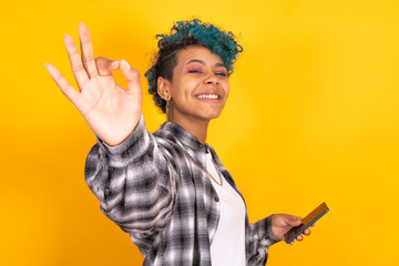 young afro american girl isolated on yellow background waving