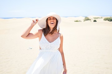 Fototapeta na wymiar Young beautiful woman smiling happy enjoying summer vacation at maspalomas dunes beach