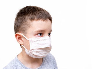 A caucasian boy in white face surgical mask on white background with copy space