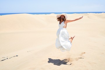 Fototapeta na wymiar Young beautiful woman jumping crazy at maspalomas dunes beach