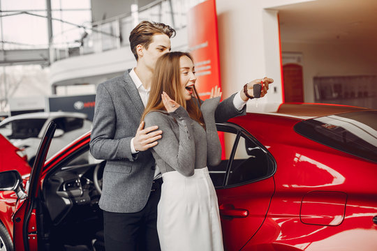 Couple buying the car. Pair in a car salon. Husband with vife choose the automobile