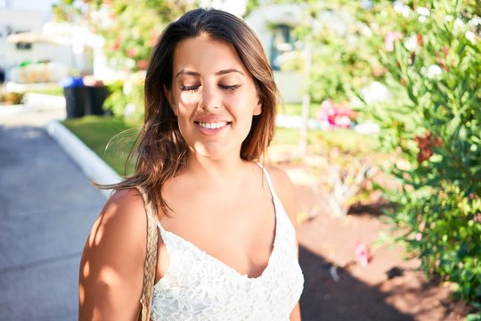 Young beautiful woman on white houses village walking on the streets on a sunny day of summer